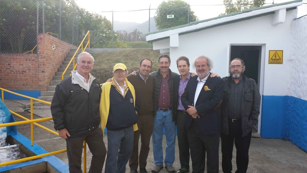 Un grupo de hombres posan para una fotografía frente a un edificio.