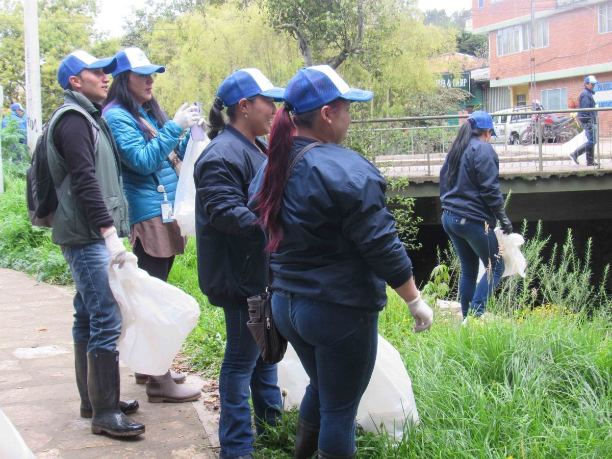 Un grupo de personas con sombreros azules están recogiendo basura.