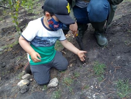 Un niño pequeño que lleva una máscara está arrodillado en el suelo.