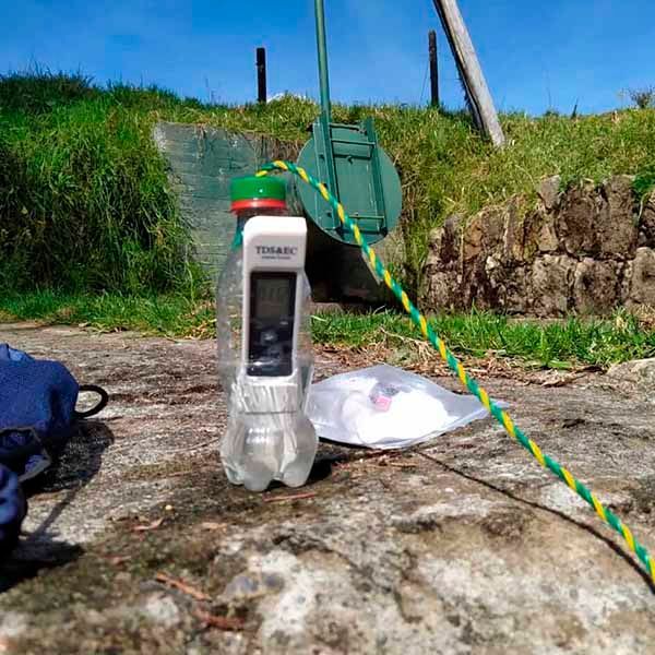 Hay un termómetro en el suelo al lado de una botella de agua.