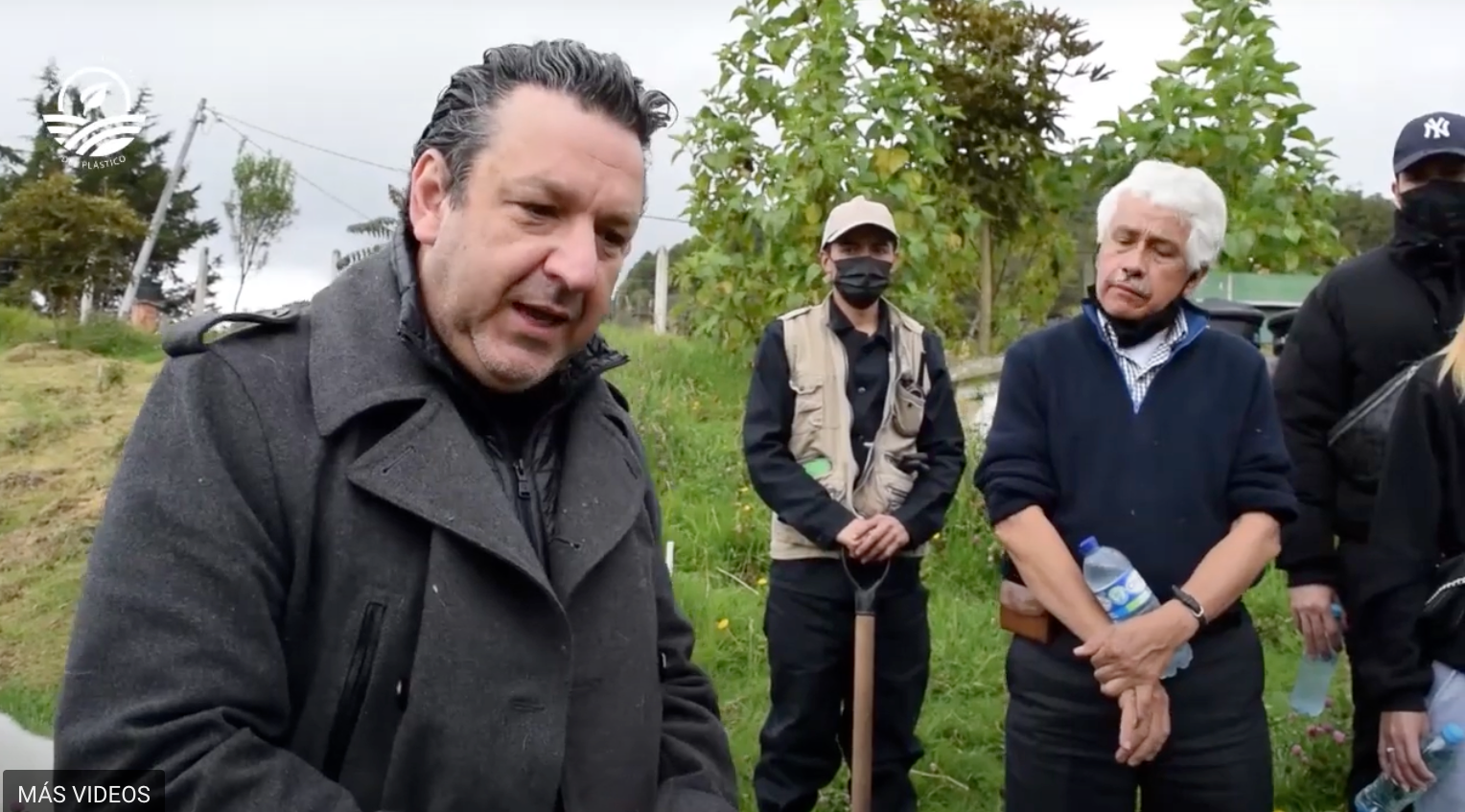 Un grupo de personas están paradas en un campo hablando entre sí.