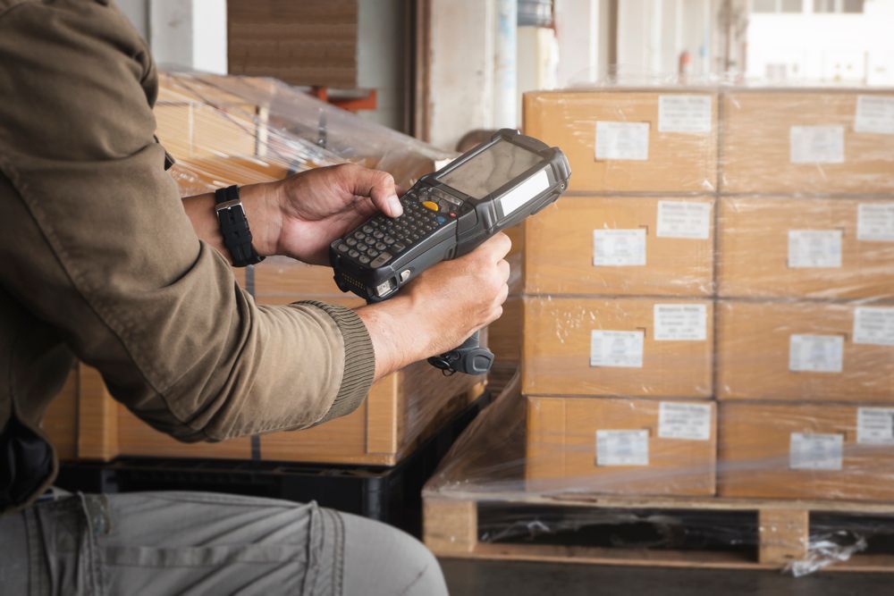 A man is using a zebra MC9300 in a warehouse.