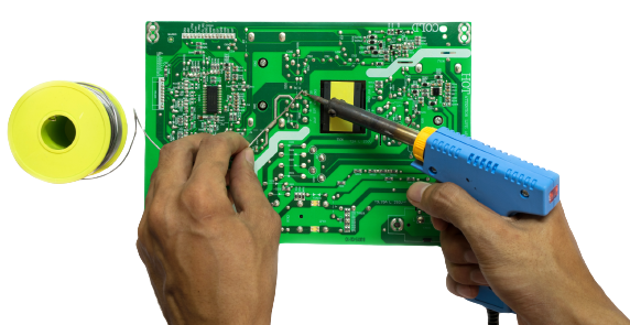 a person is soldering a motherboard with a soldering iron.