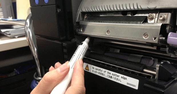 a person is cleaning a thermal printer