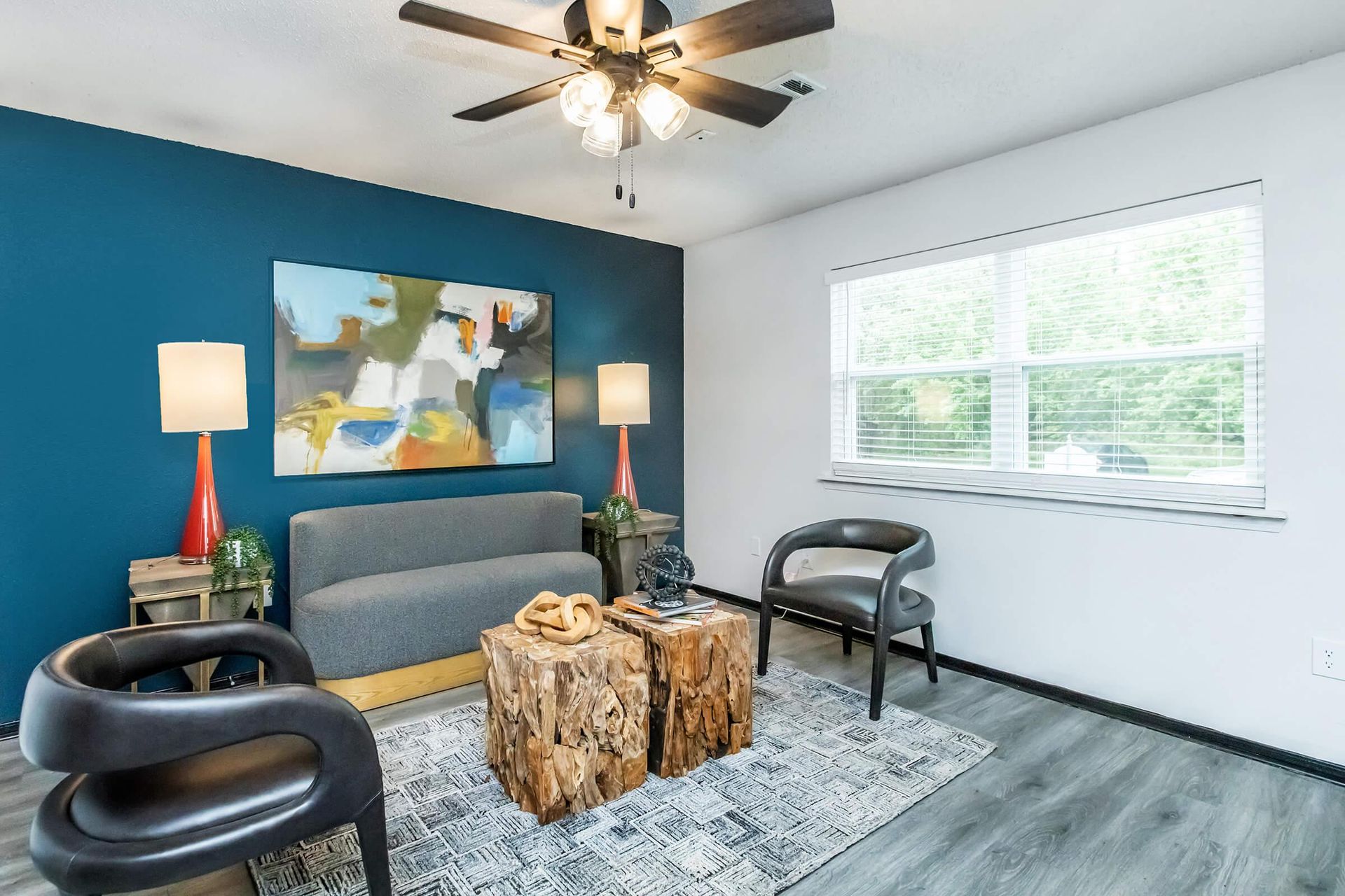 A living room with a couch , chairs , and a ceiling fan at Mill Creek.