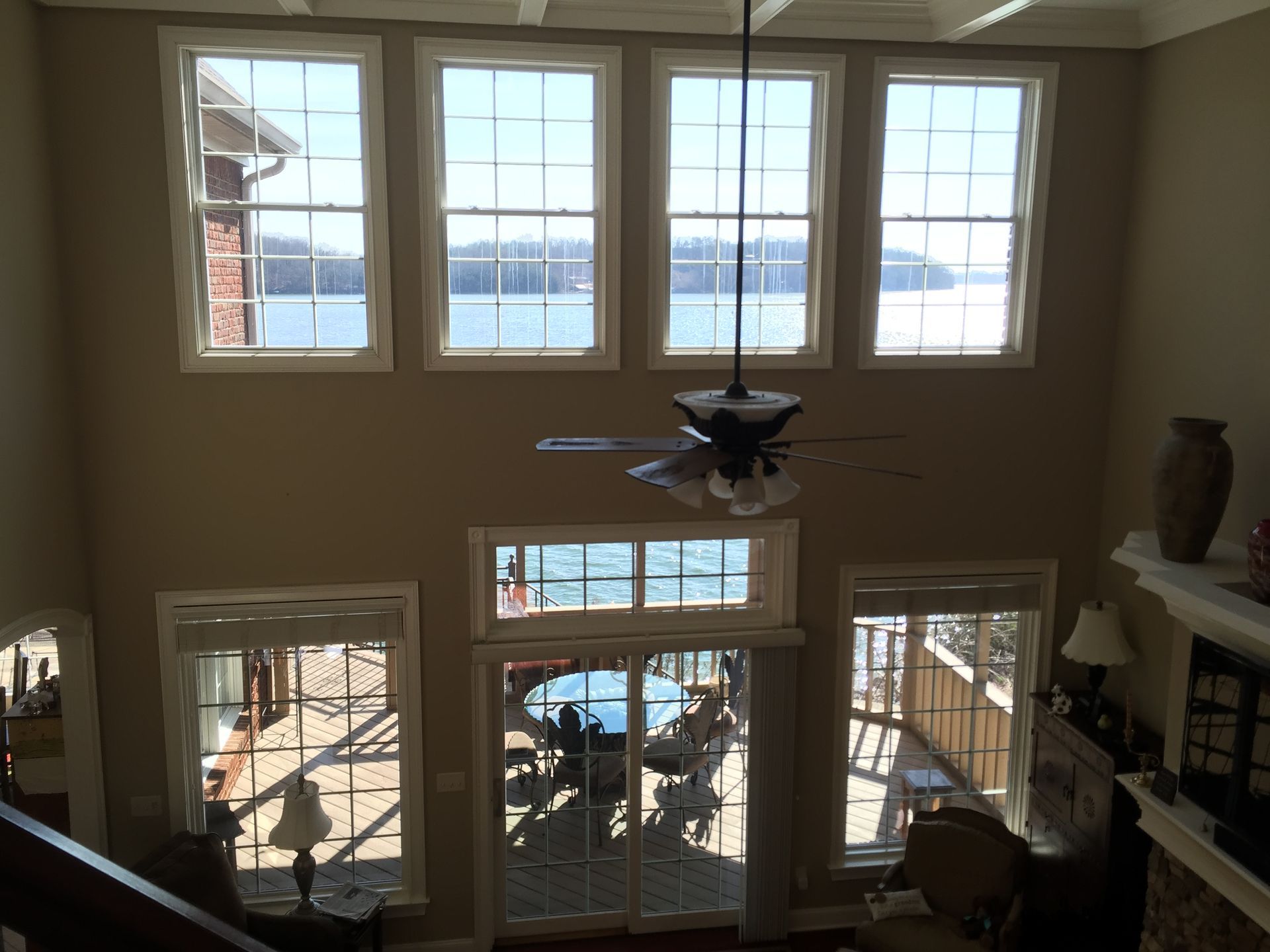 A living room with a lot of windows and a ceiling fan.