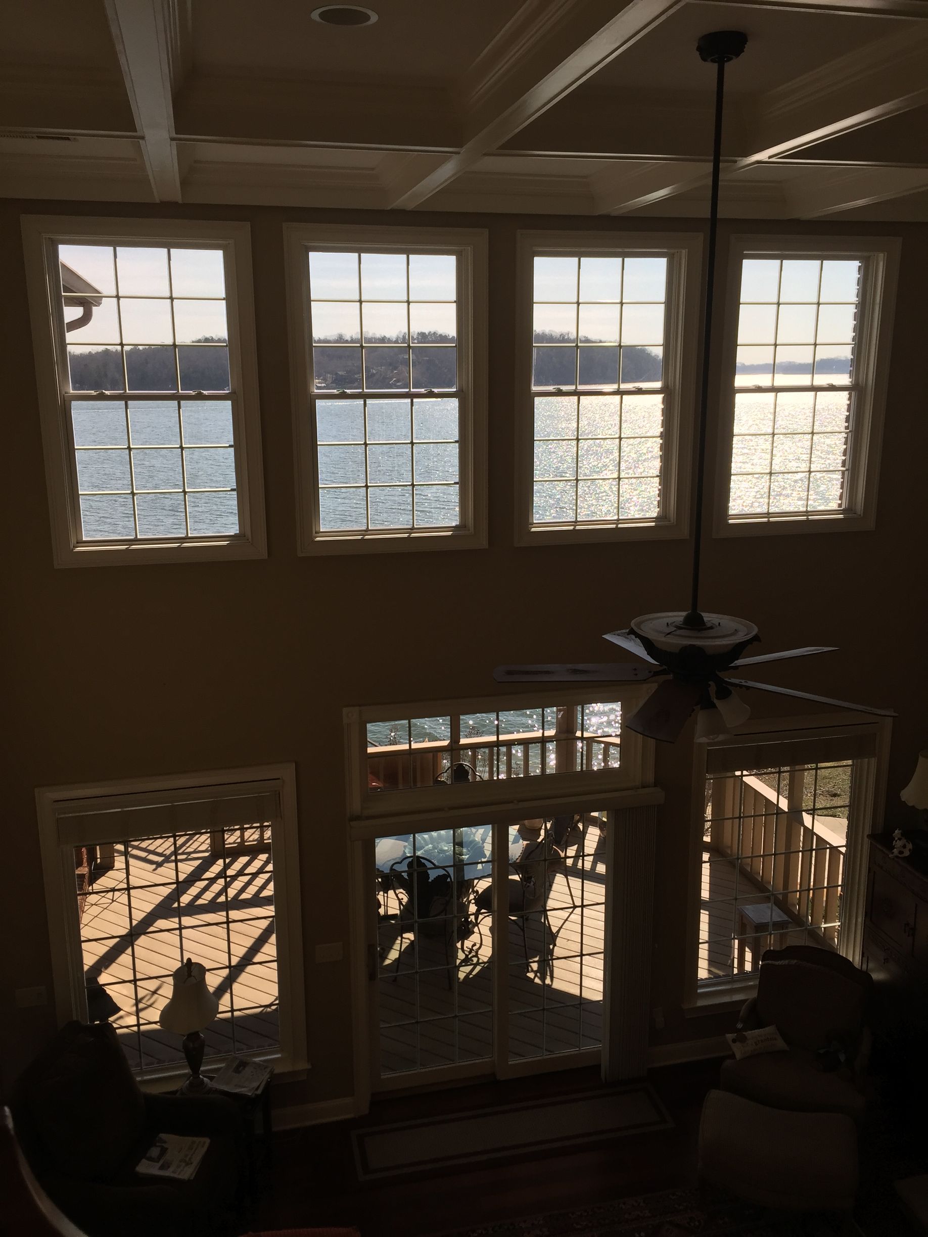 A room with a lot of windows and a ceiling fan