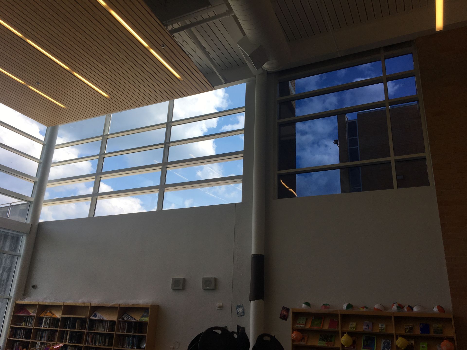 A library with a lot of windows and a blue sky behind them