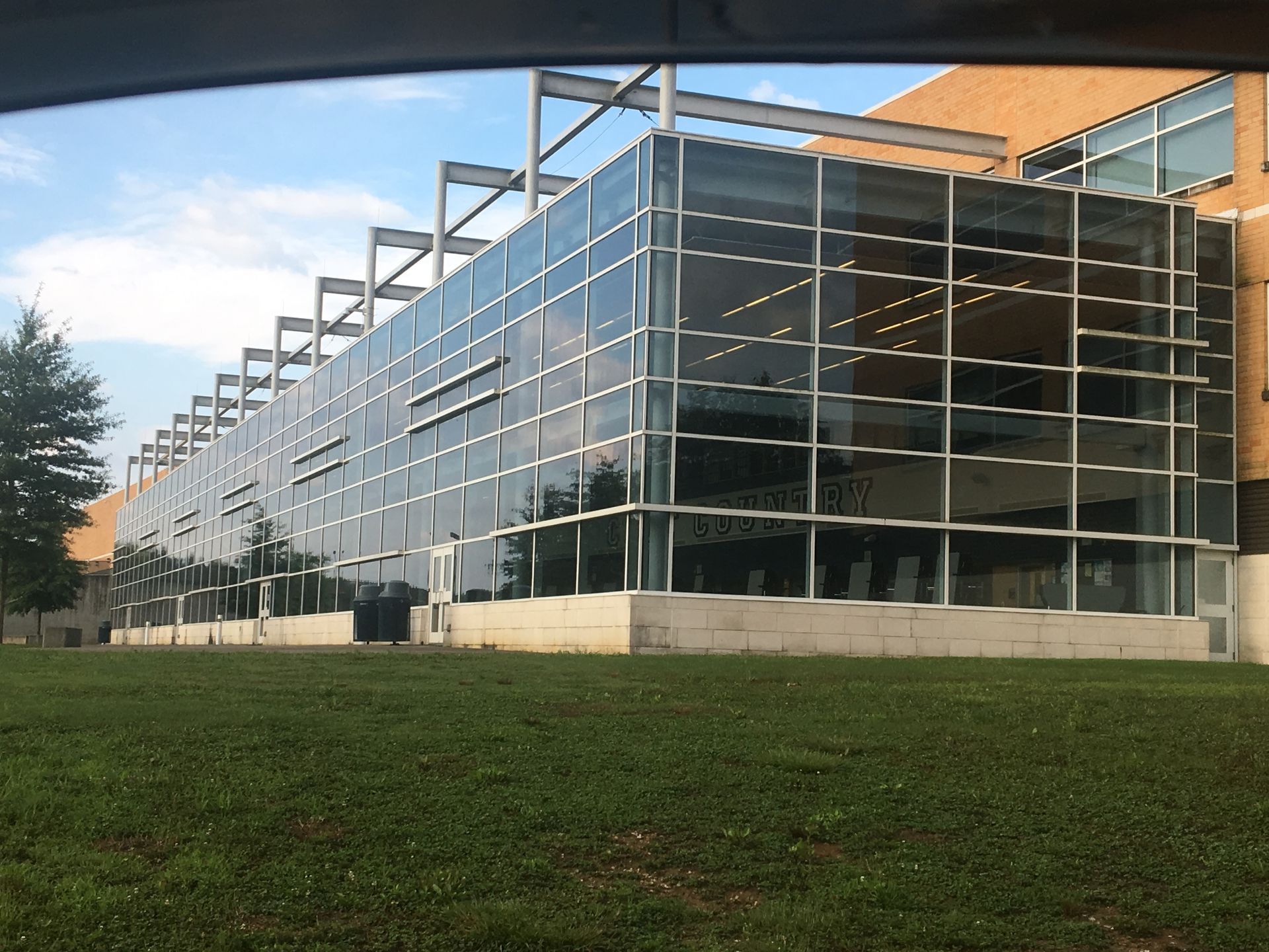A large building with a lot of windows is surrounded by grass