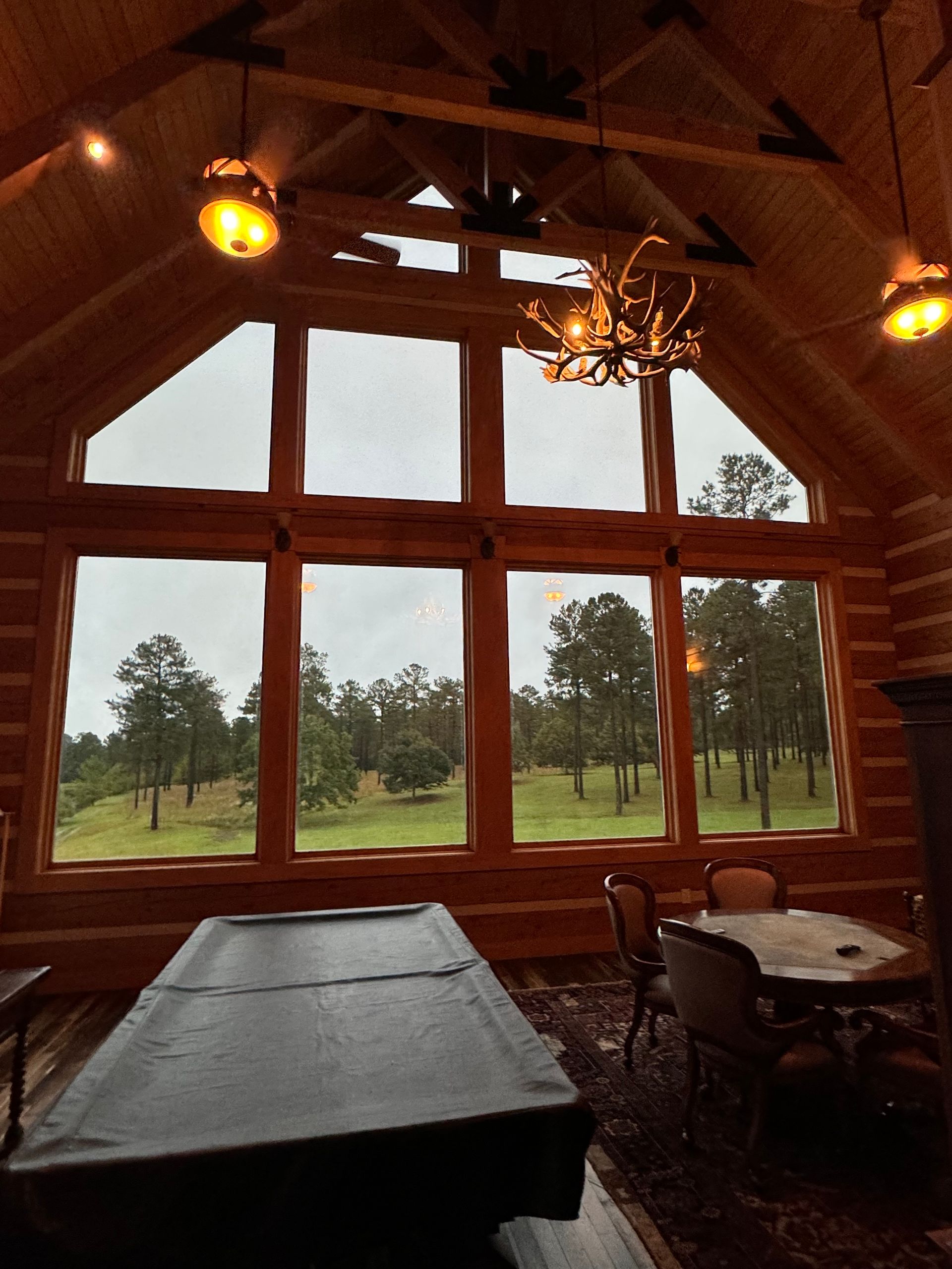 A pool table in a room with lots of windows