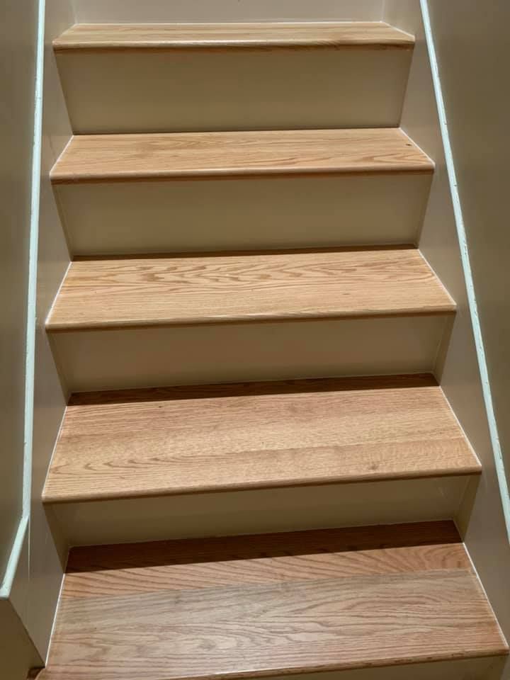 A set of stairs with wooden steps and a white railing.