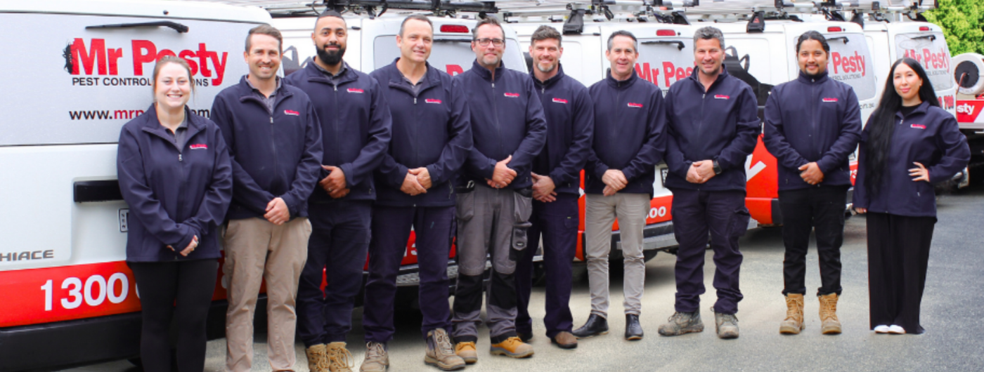 Photo of Mr Pesty team in front of Pest Control trucks. 
