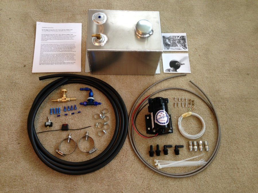 A stainless steel tank is surrounded by various pieces of equipment