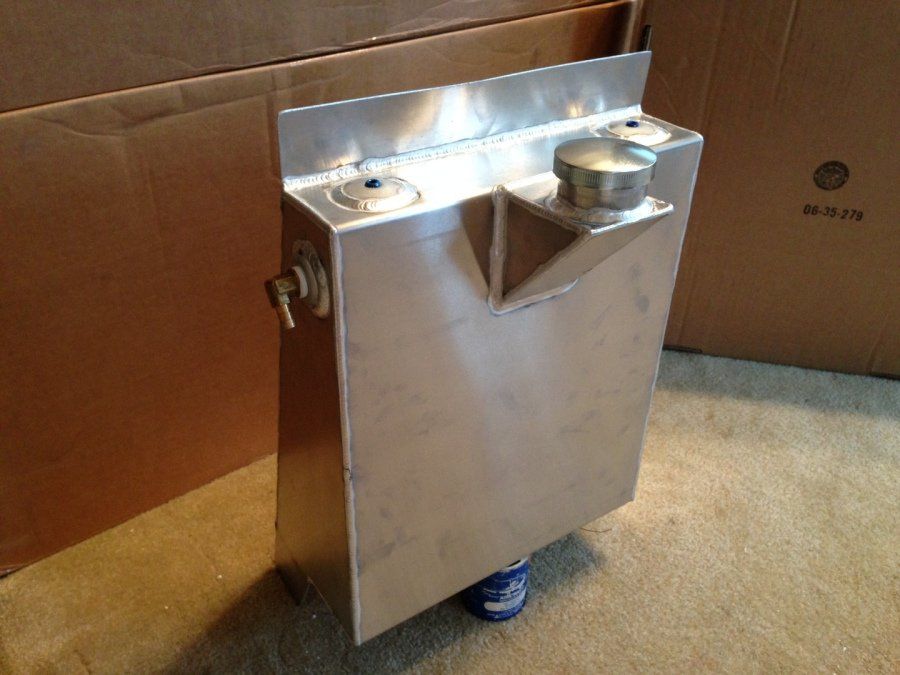 A stainless steel container is sitting in front of a cardboard box