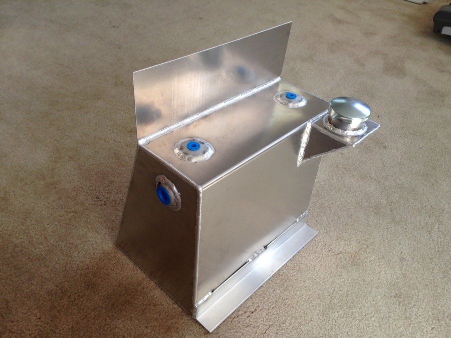 A metal item with blue buttons on it is sitting on a carpeted floor