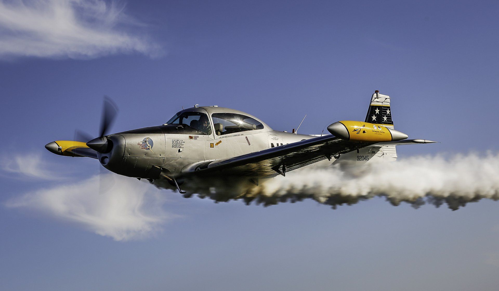 A small propeller plane is flying through a blue sky.