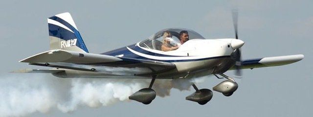 A small plane is flying in the sky with smoke coming out of it