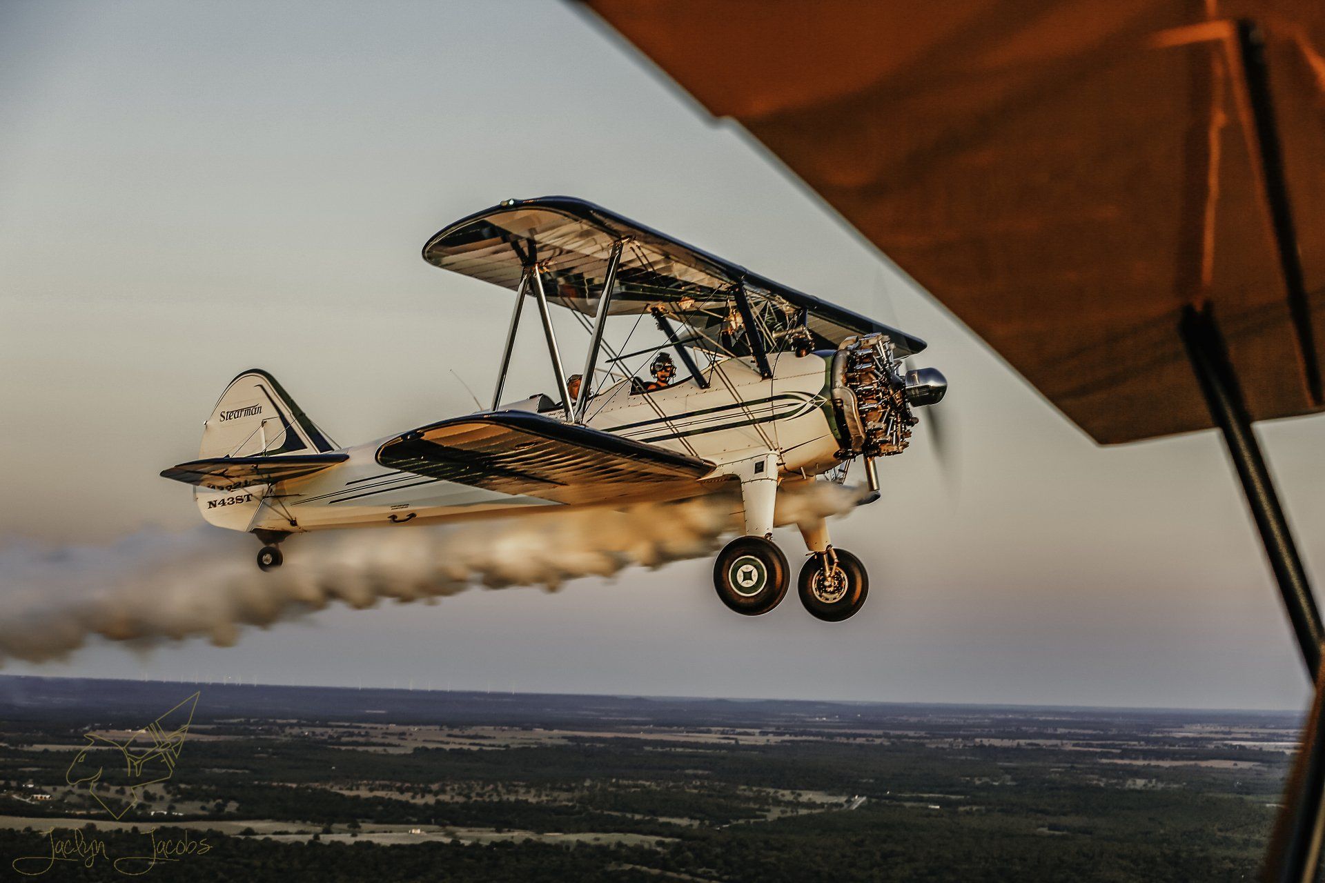 A small plane is flying over a body of water.