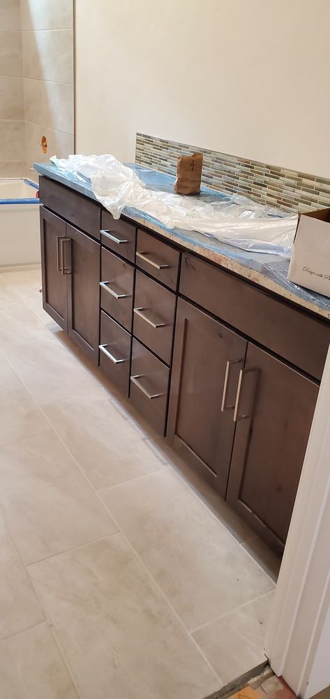 A bathroom with a sink , cabinets and drawers.