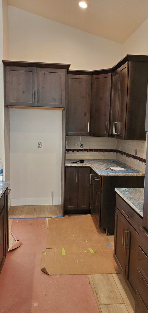 A kitchen with wooden cabinets and marble counter tops is being remodeled.