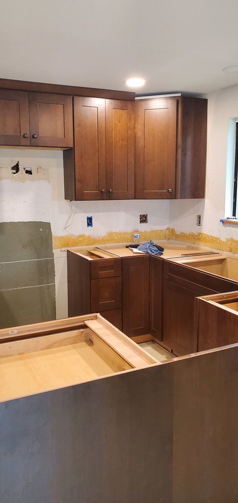 A kitchen is being remodeled with wooden cabinets and counter tops.