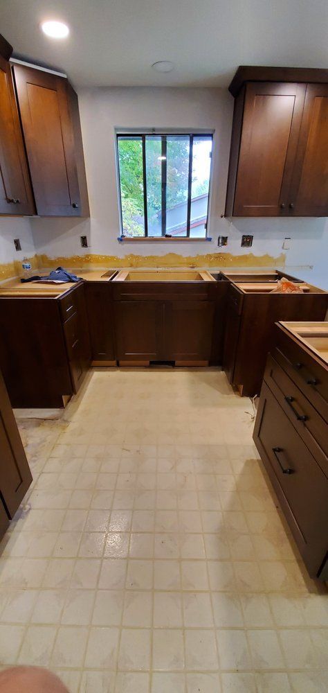 A kitchen with wooden cabinets and a window.