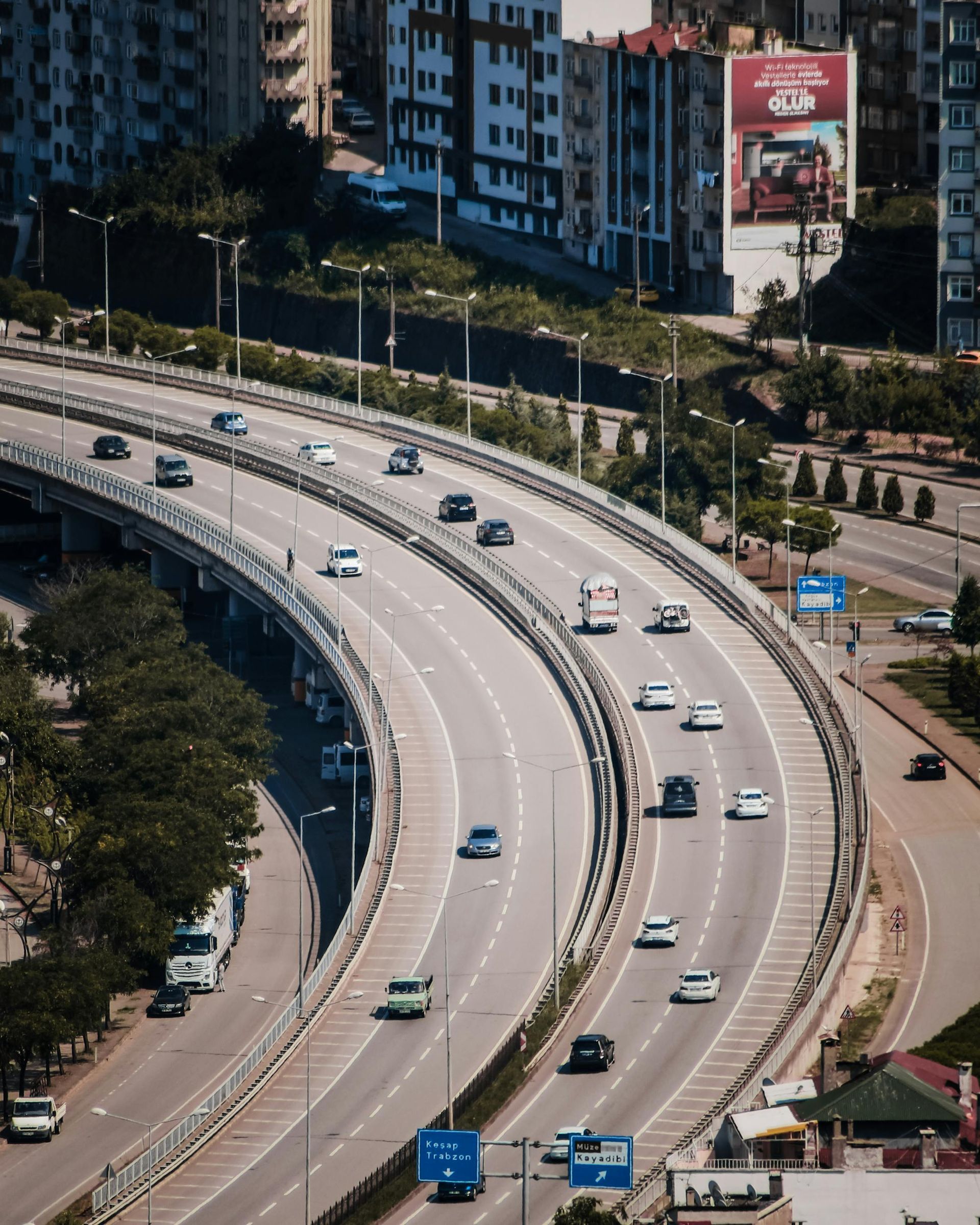 Curving elevated highway with light traffic beside a canal and city buildings