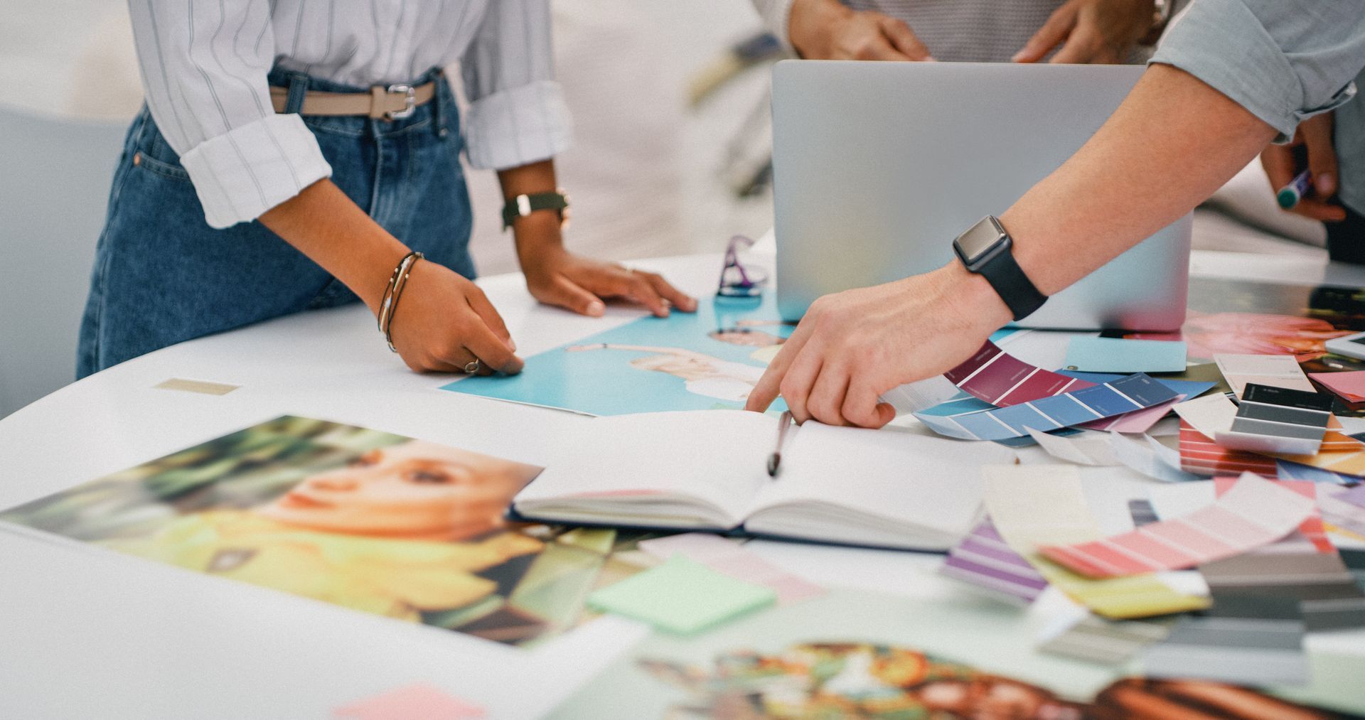 Un gruppo di persone è seduto a un tavolo e guarda un computer portatile.
