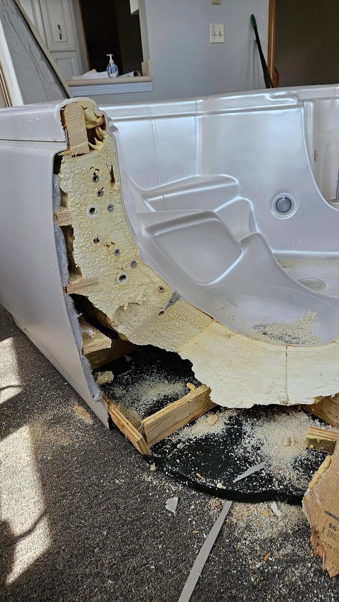 A bathtub with a hole in it is sitting on the floor.