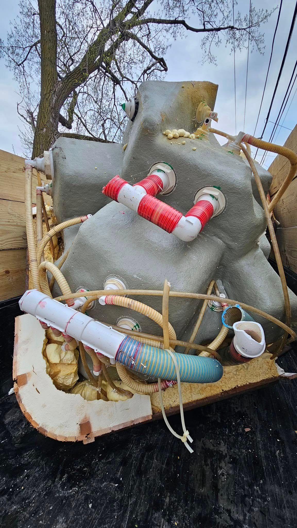 A statue of an elephant is sitting on top of a pile of trash.