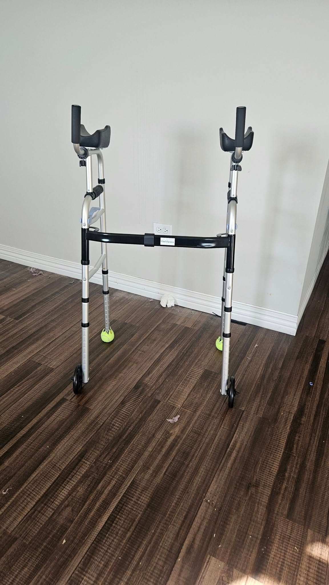 A walker is sitting on a wooden floor in a room.