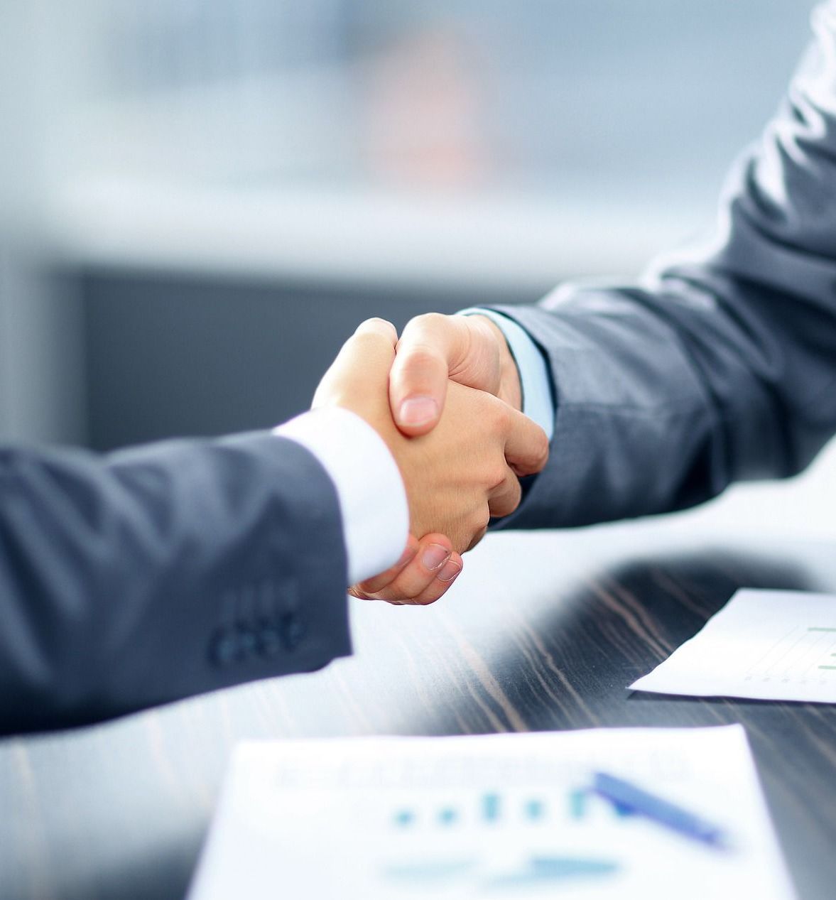 A man in a suit shakes hands with another man
