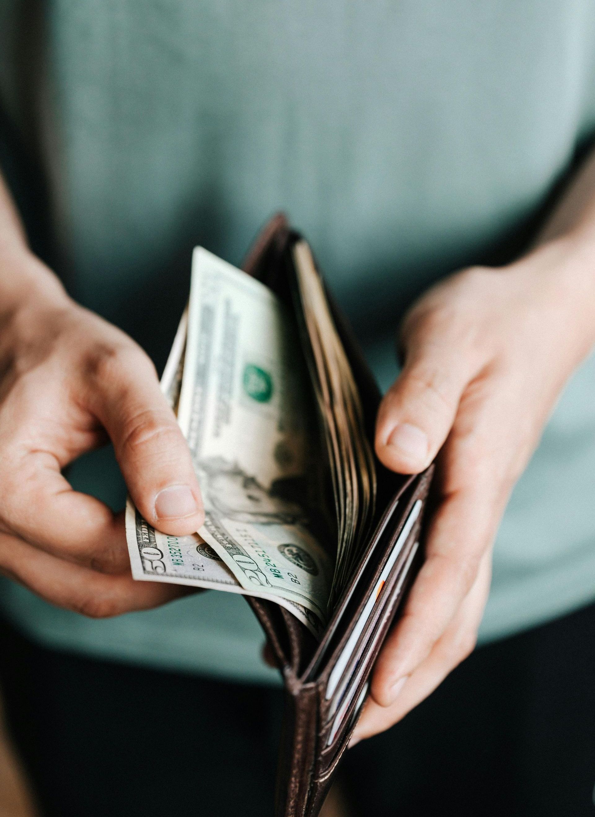 A person is taking money out of their wallet.