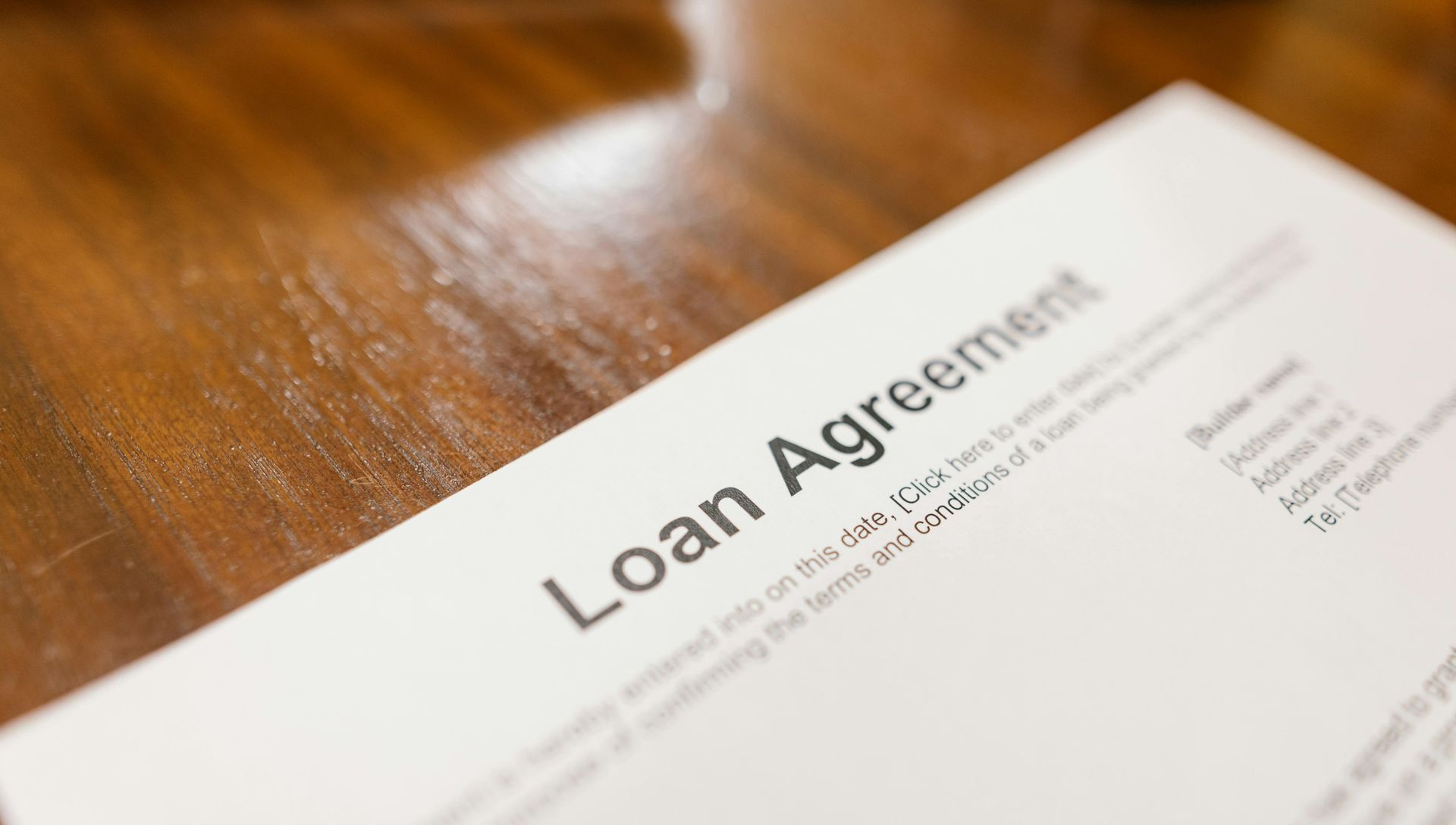 Loan agreement document on a wooden table.
