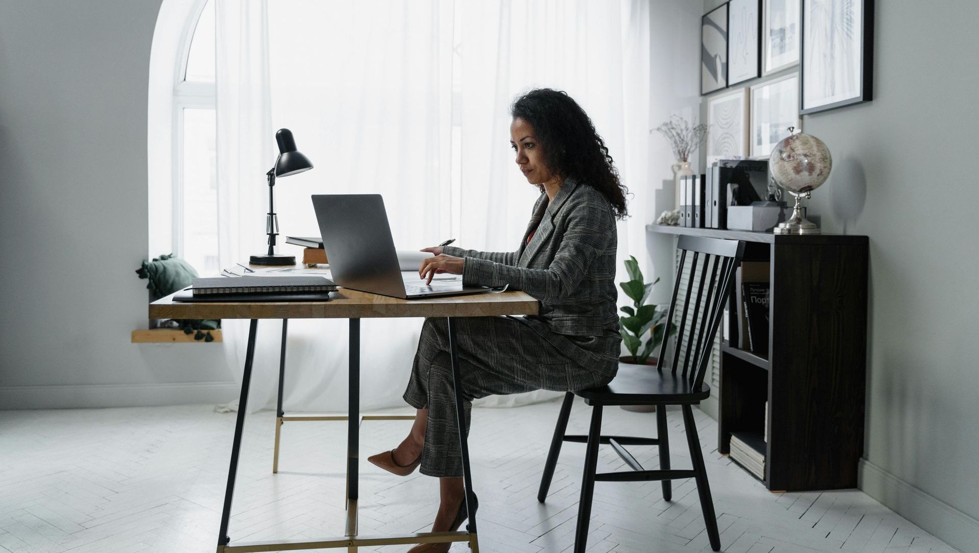 A woman is sitting on a couch using a laptop computer.