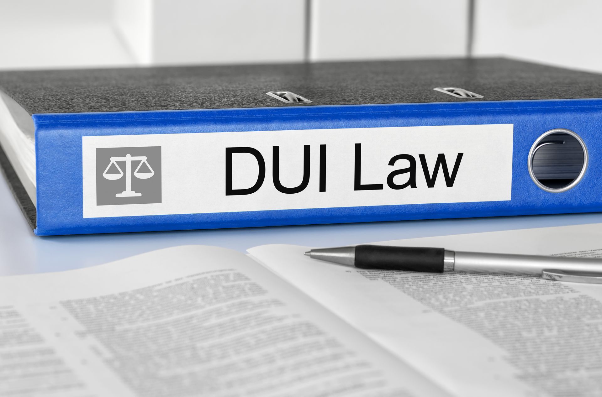 DUI Law binder on desk with legal documents representing DUI ADSAC evaluation requirements. DUI Law binder on desk with legal documents representing DUI ADSAC evaluation requirements.