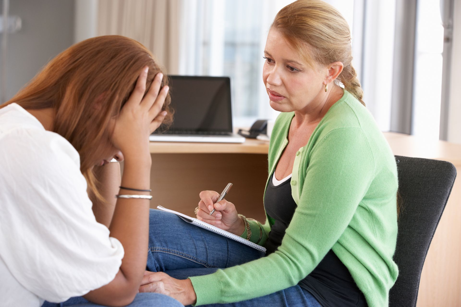A counselor speaking with a distressed woman during a substance abuse assessment session. A counselor speaking with a distressed woman during a substance abuse assessment session.