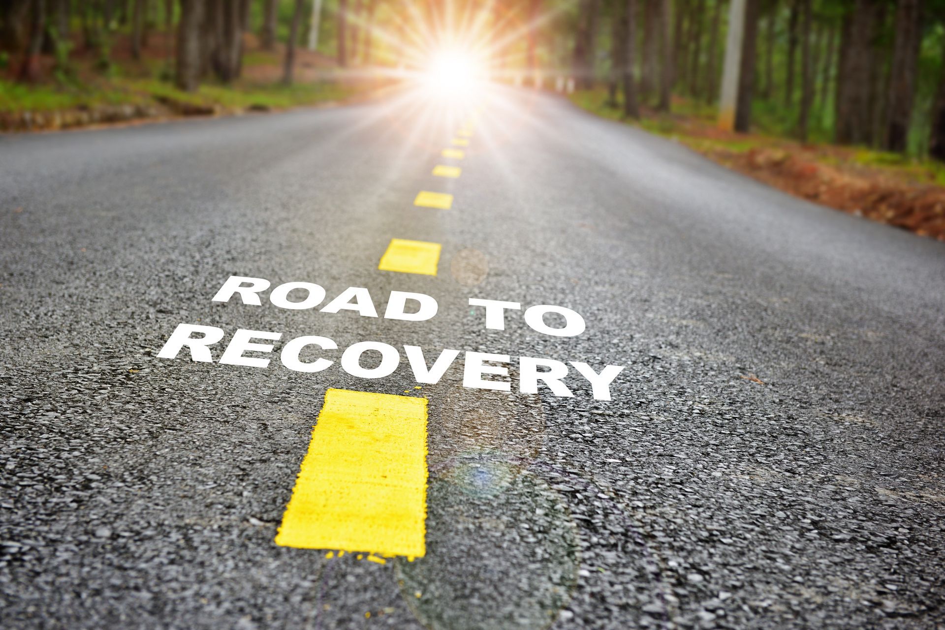 A sunlit road symbolizing the journey of overcoming addiction and moving toward recovery