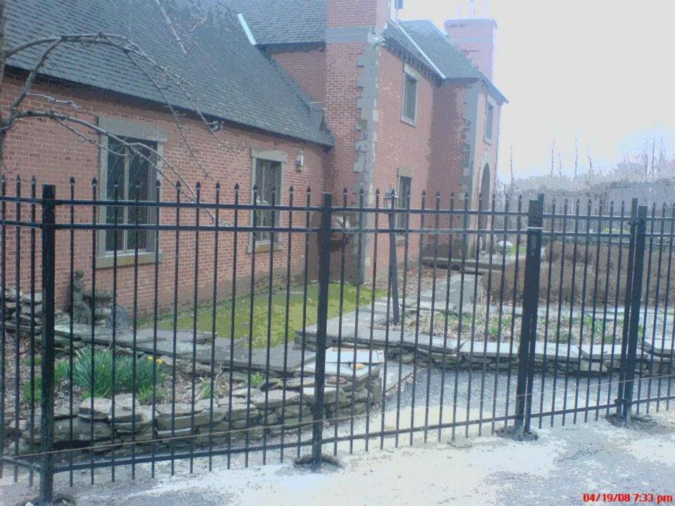 A brick building with a metal fence in front of it
