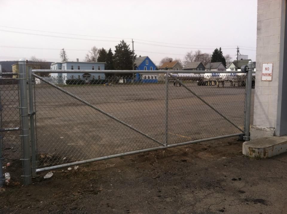 A chain link fence surrounds a large empty parking lot