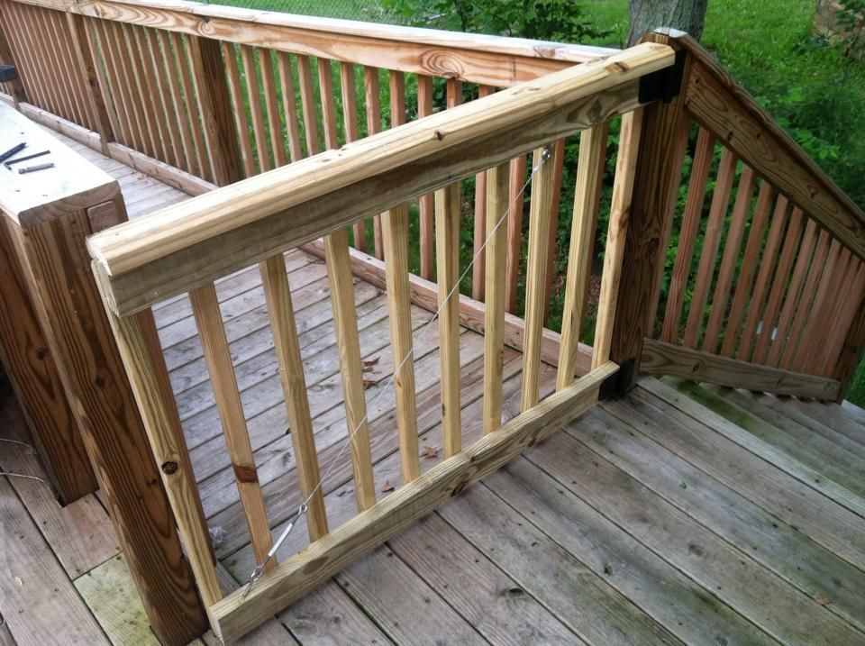 A wooden deck with stairs and a wooden railing.