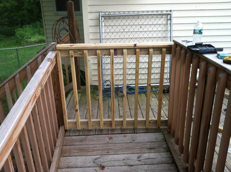 A wooden deck with a chain link fence in the background