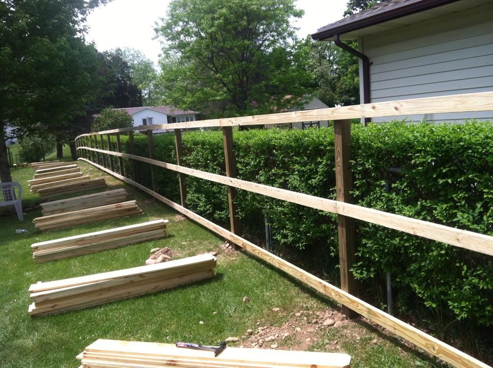 A wooden fence is being built in front of a house