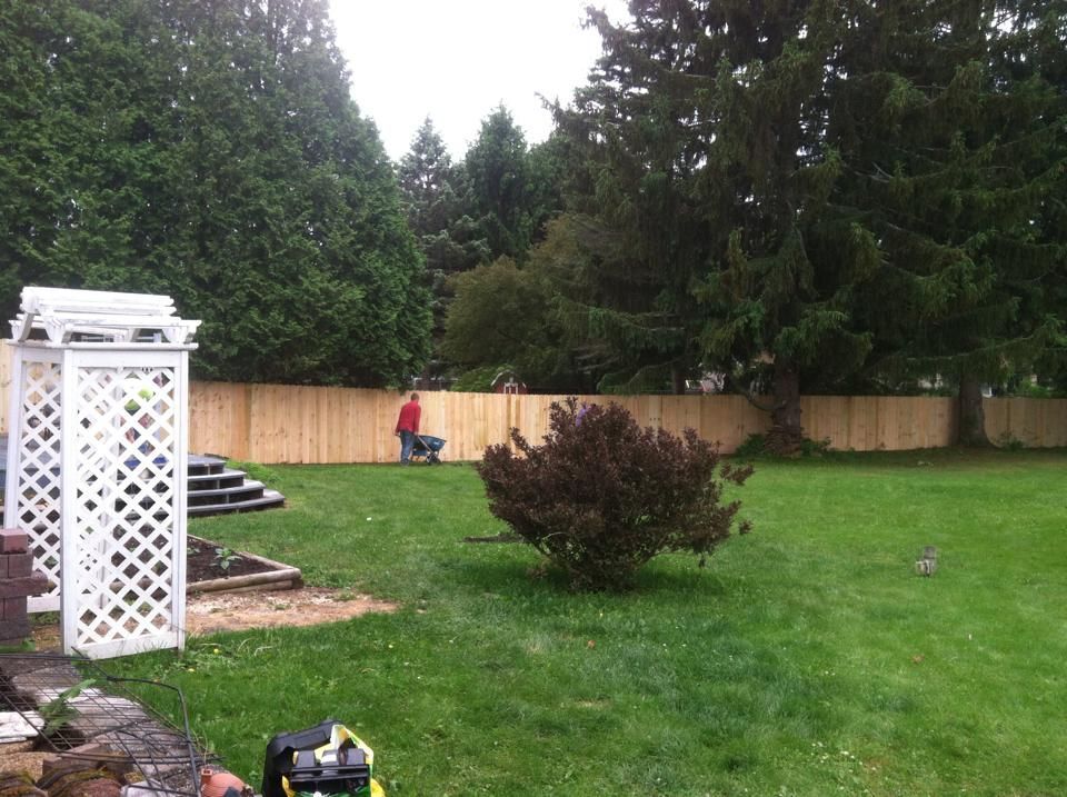 A backyard with a wooden fence and stairs
