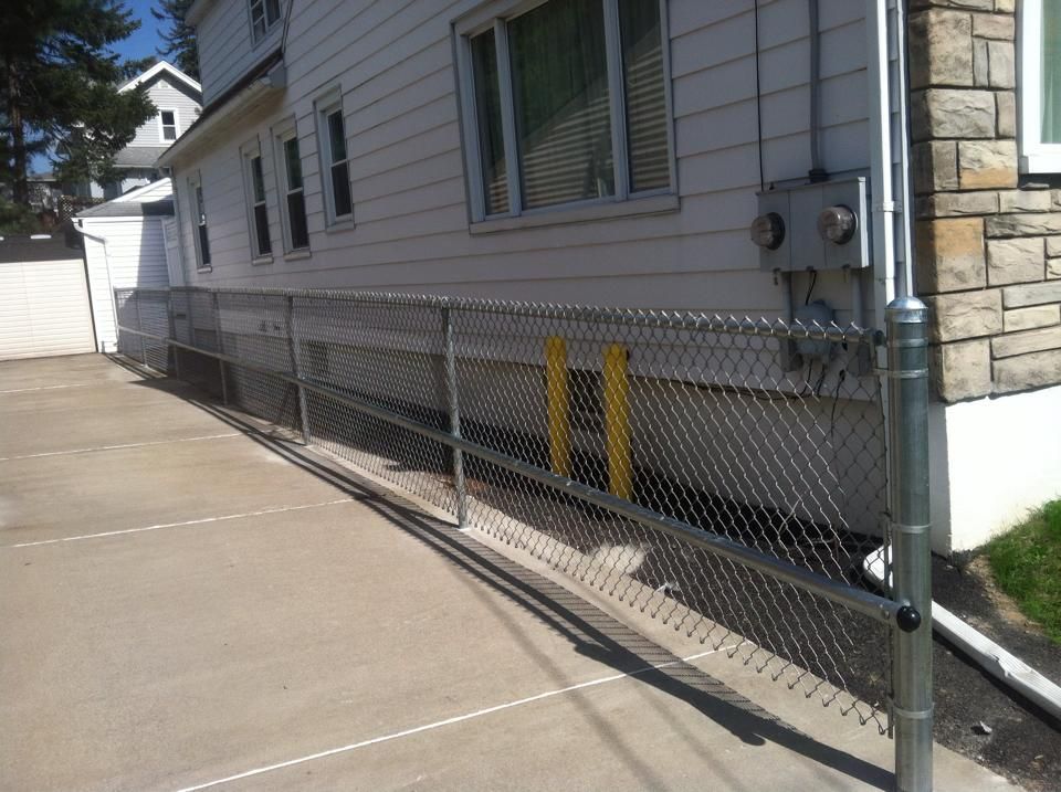A chain link fence along the side of a house