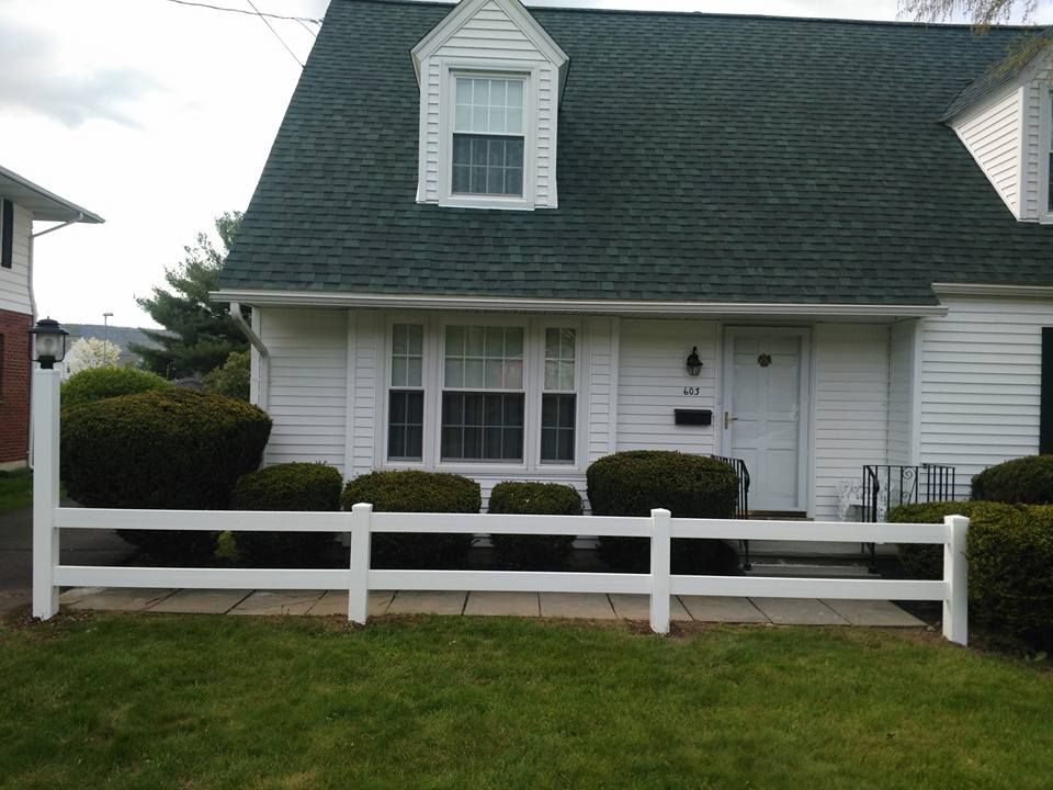 A white house with a white fence in front of it