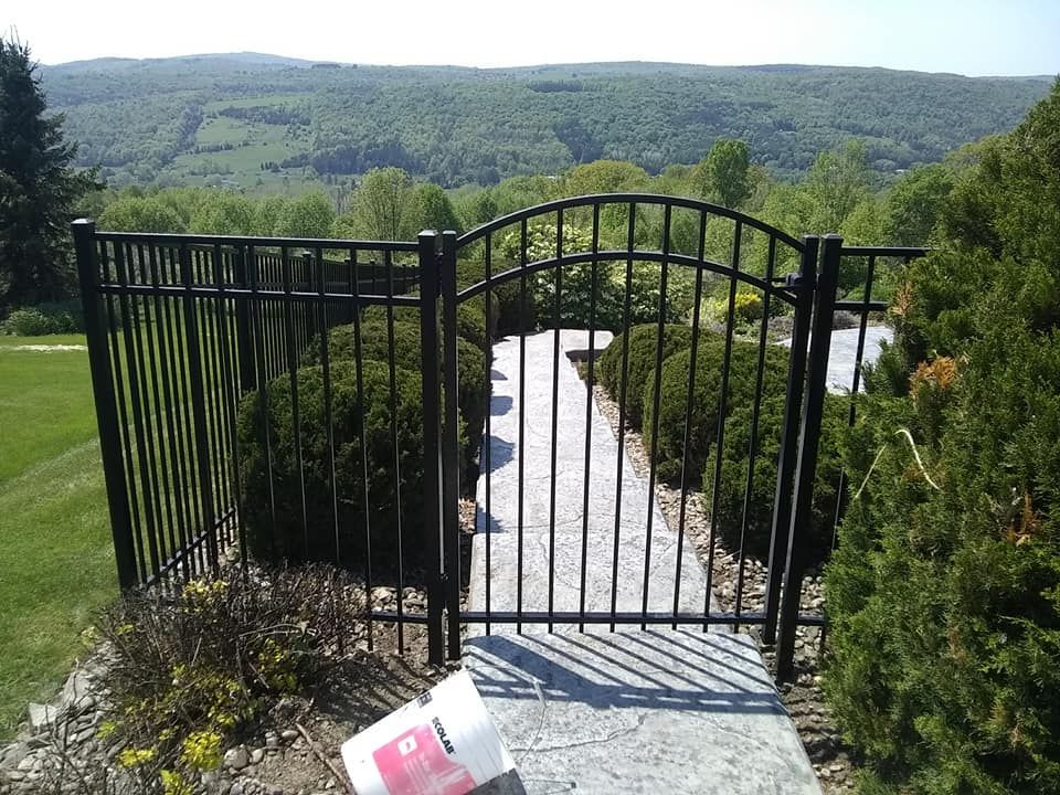 A black fence with a bucket in front of it