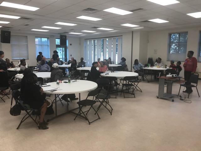 A group of people are sitting at tables in a large room.