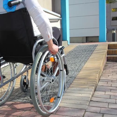 A person in a wheelchair is going down a ramp