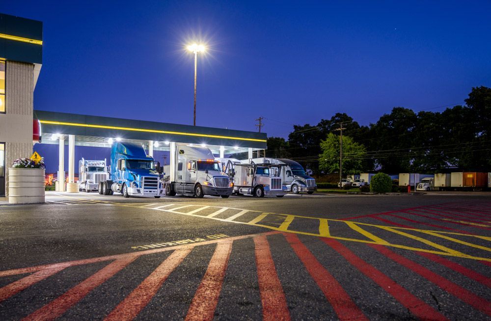 A Row of Semi Trucks Are Parked at A Gas Station at Night — Top End Line Markers Pty Ltd in Katherine, NT